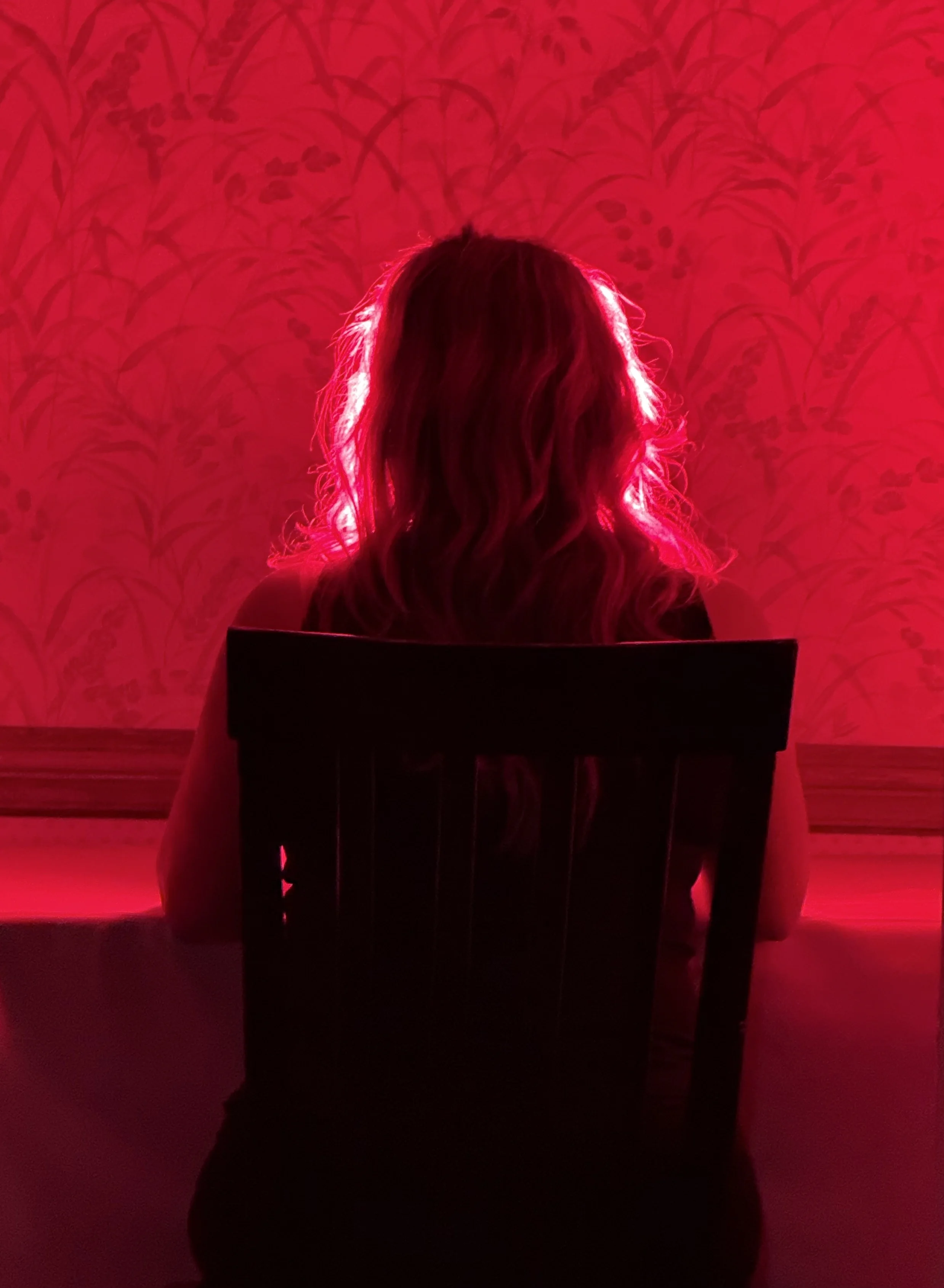 A person resting in front of a warm red light